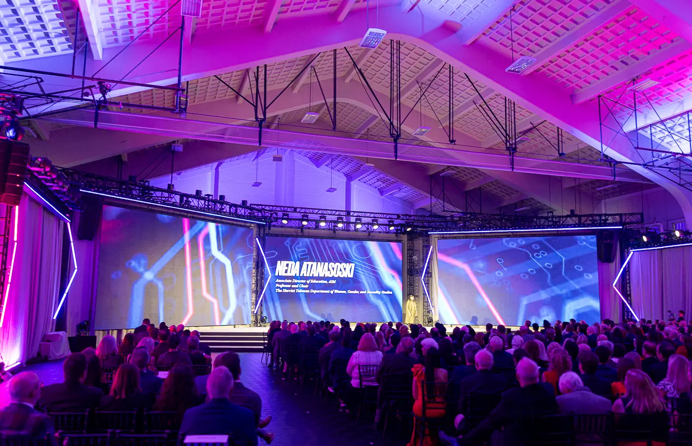 A fundraising event filled with purple and blue stage lighting